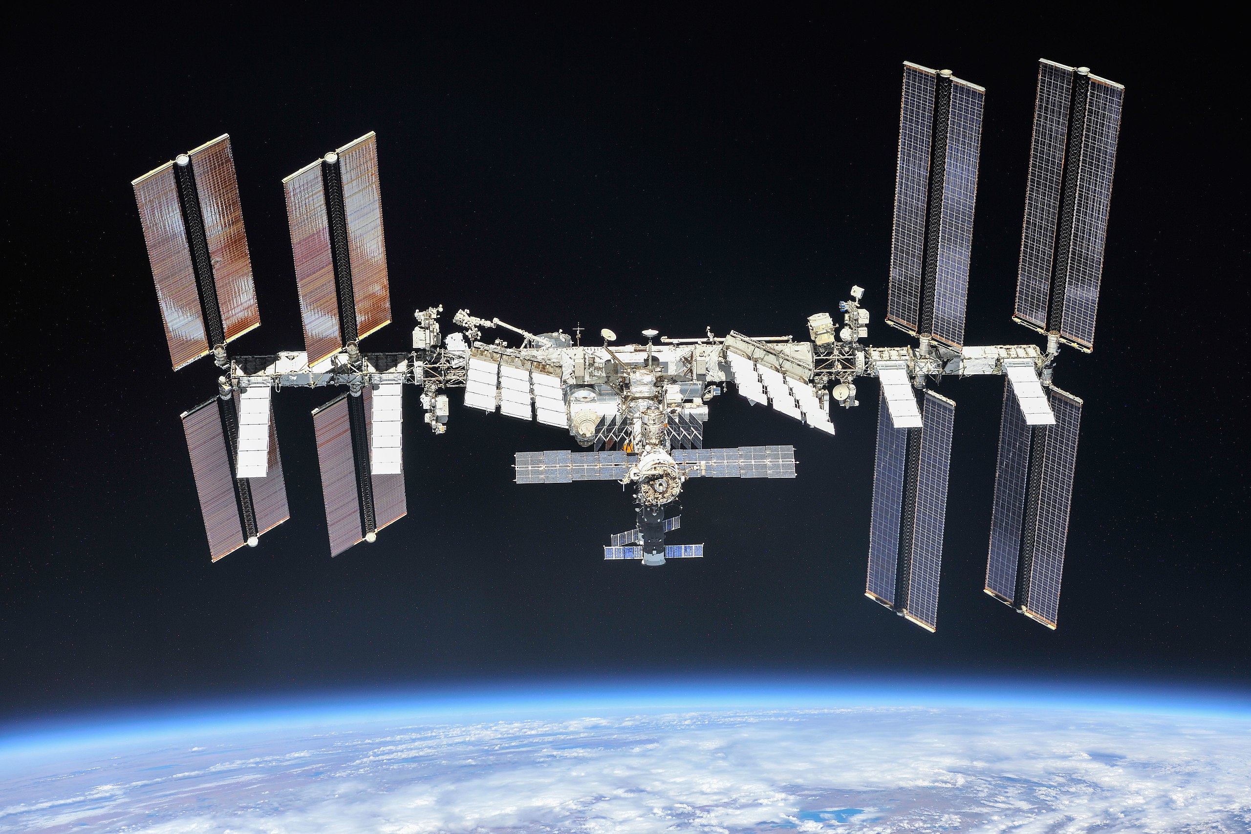 The complex structure of the International Space Station shown above the curvature of part of Earth's surface.