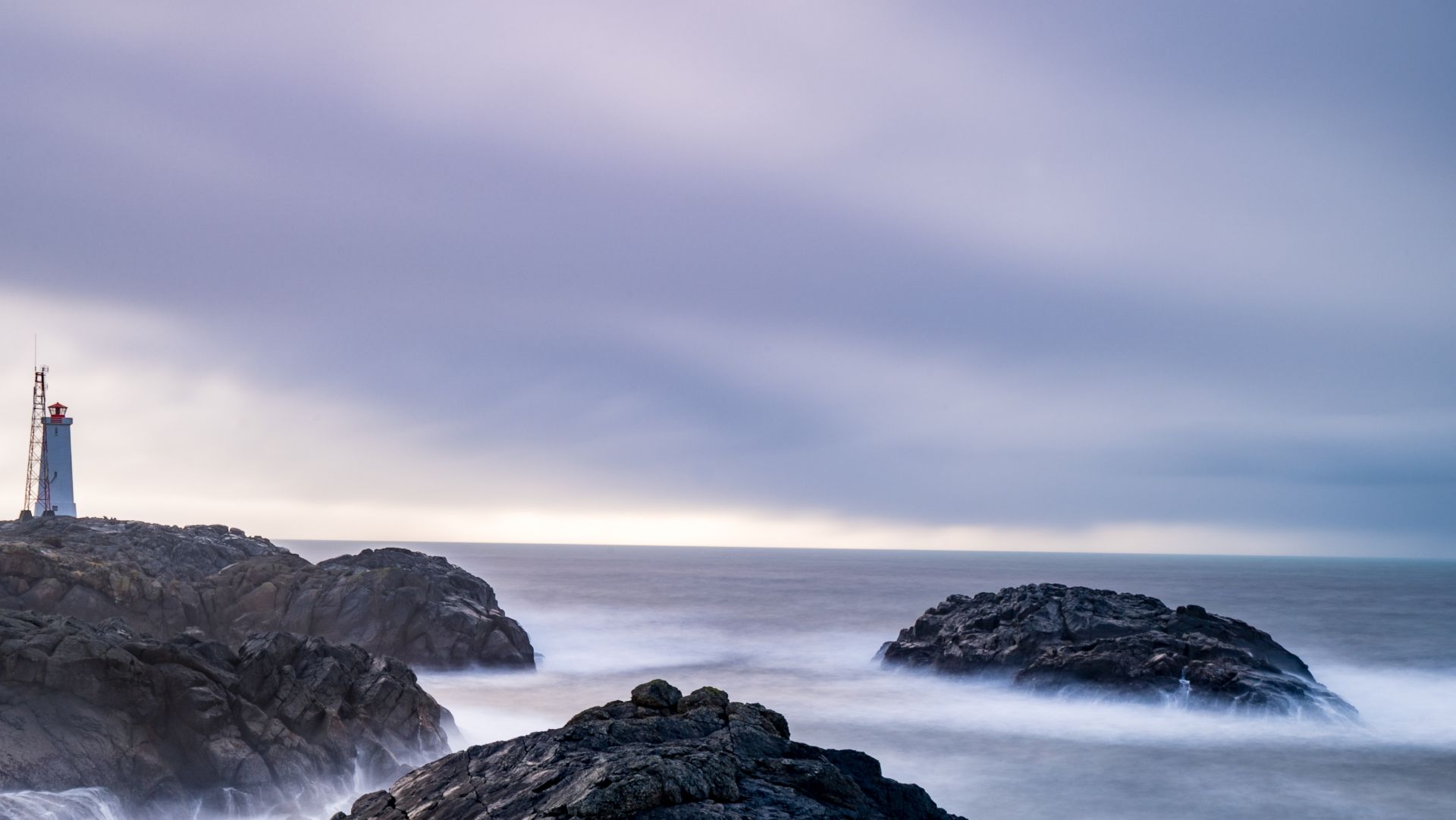 An ocean view with a rocky coast and lighthouse