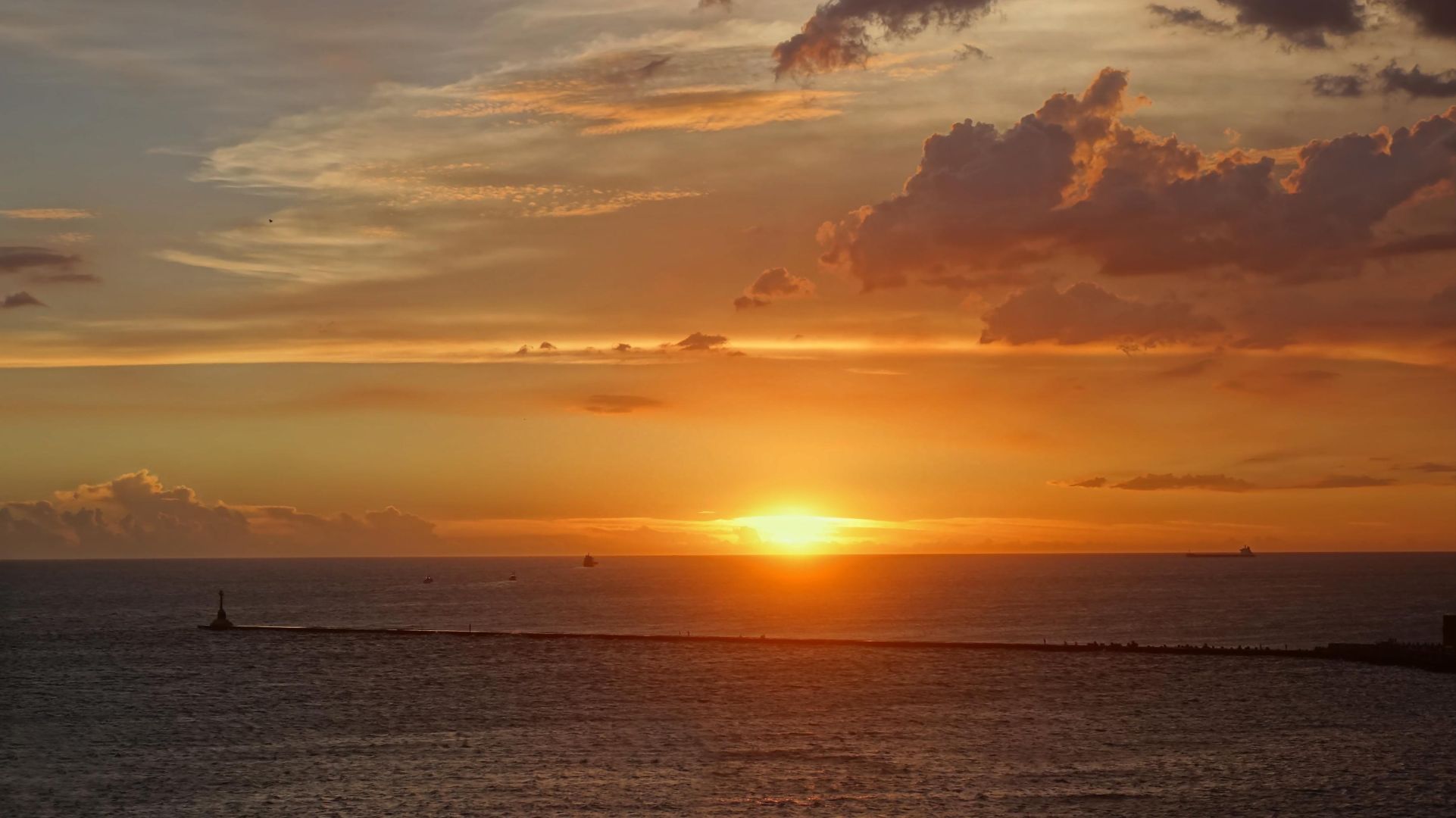 An ocean view with an orange sunset